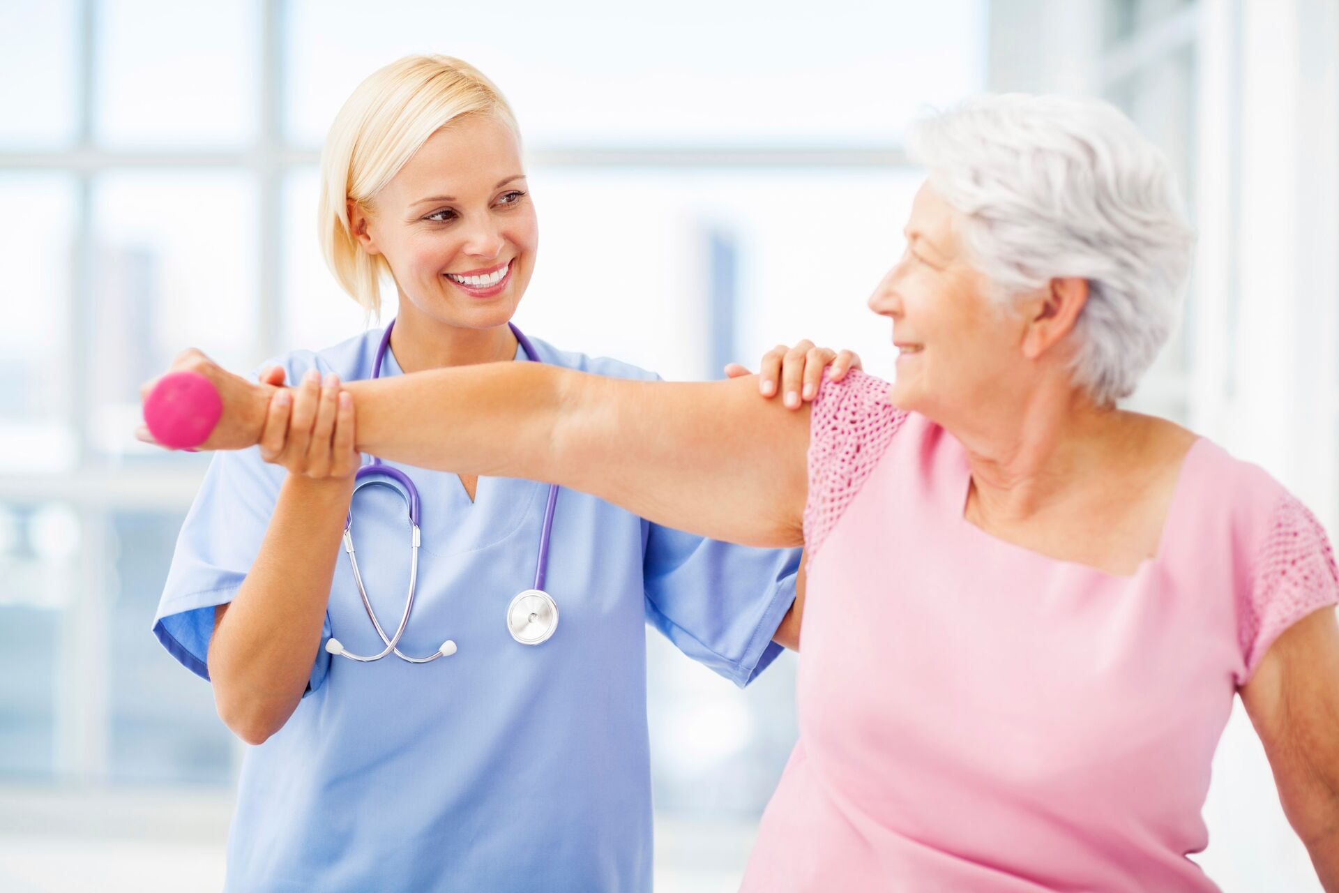 Senior woman doing physical therapy with a nurse