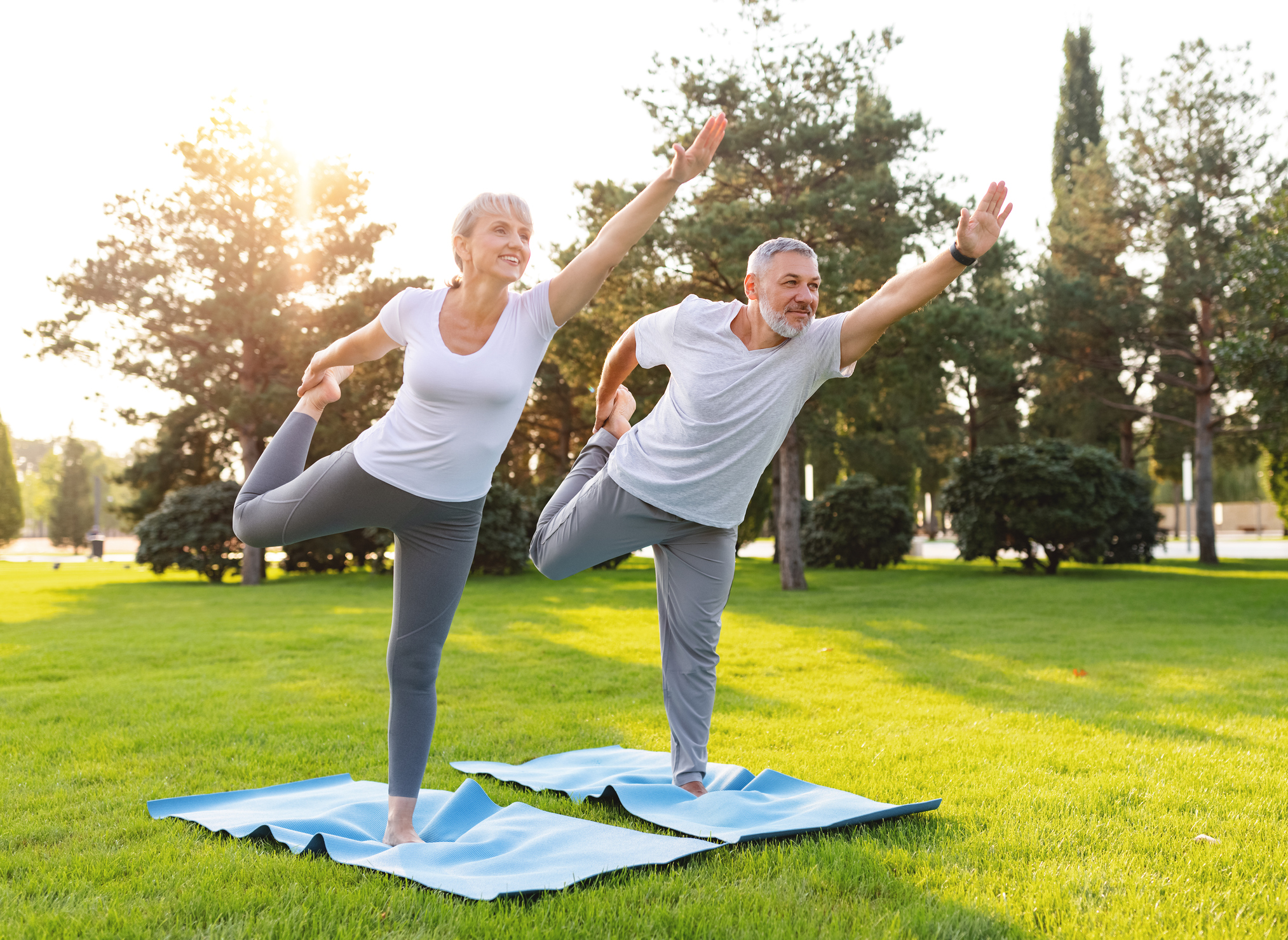 Two older adults enjoying yoga outside