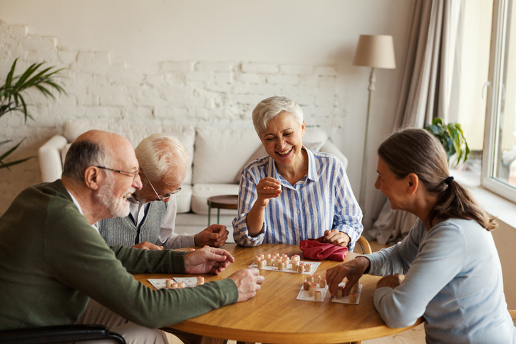 A group of seniors playing social games at a small table
