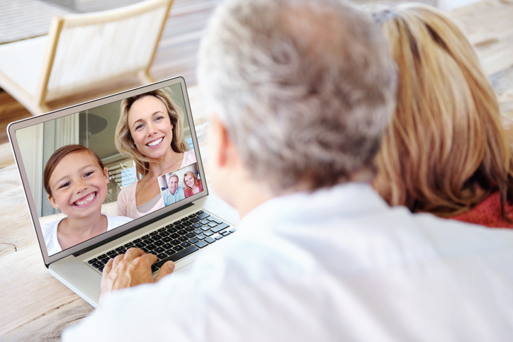 Senior couple enjoying a video call with their daughter and granddaughter