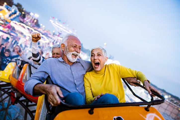 Senior couple riding a rollercoaster at an amusement park